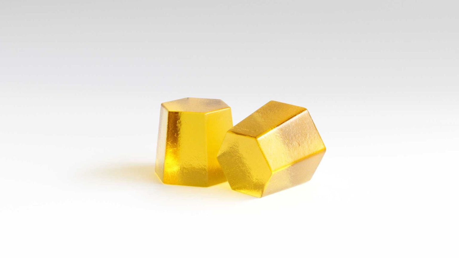 Two yellow gummy supplements shaped like geometric crystals